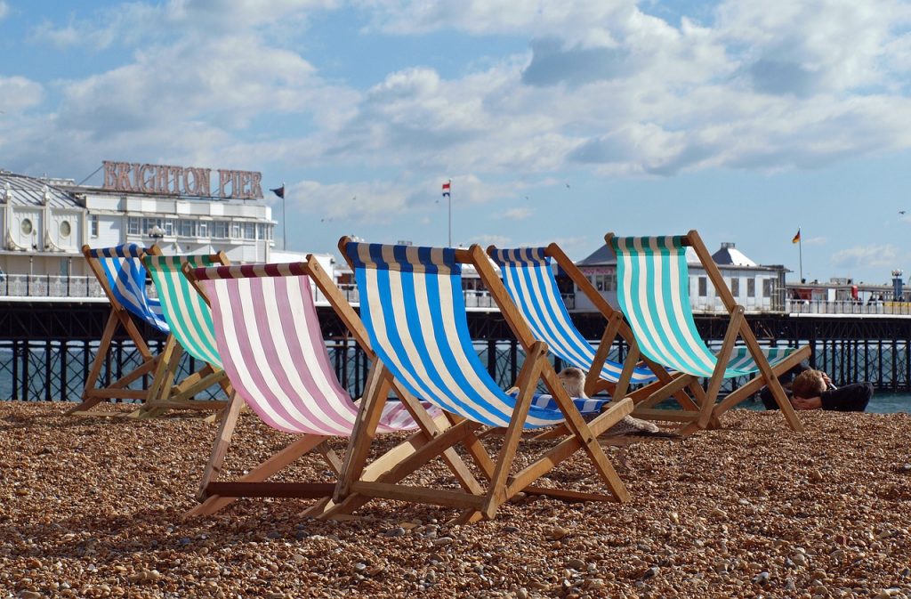 Deckchairs on Brighton Beach with Brighton Pier in the background 
