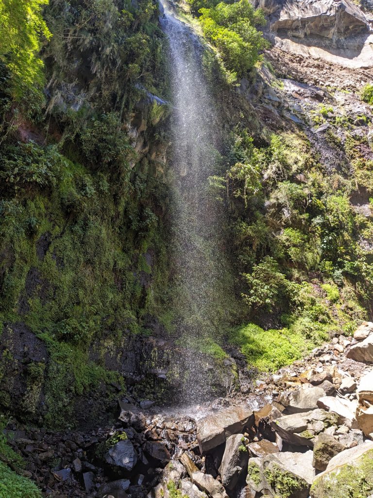 Waterfall at the end of the Pipeline Hiking Trail in Boquete, Panama, surrounded by mossy cliff walls and cloud forest vegetation